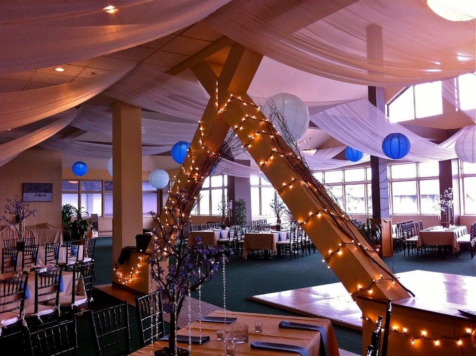 Wide Indoor wedding venue with lights and tables and chairs