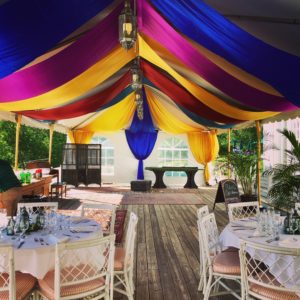 Rainbow top design in wedding venue with white chairs